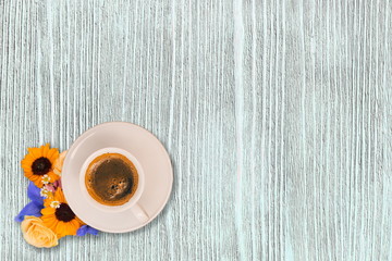 Cup of morning coffee and fresh flowers on light wooden table. Place for text