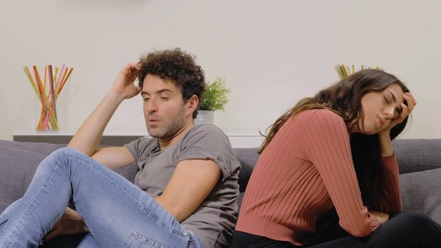 sad and frustrated couple sitting on the couch, they fail to have a child