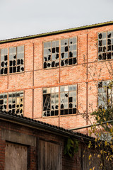 Fototapeta premium Old destroyed brick house ruin with broken windows