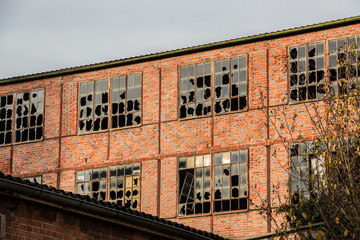 Fototapeta premium Old destroyed brick house ruin with broken windows