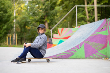 Young sporty girl riding on longboard in park.