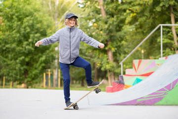 Skater girl on skatepark moving on skateboard outdoors. Copy space