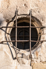 Old historical building with a lattice made of steel in front of the round window