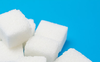 Sugar cubes over blue background with copyspace