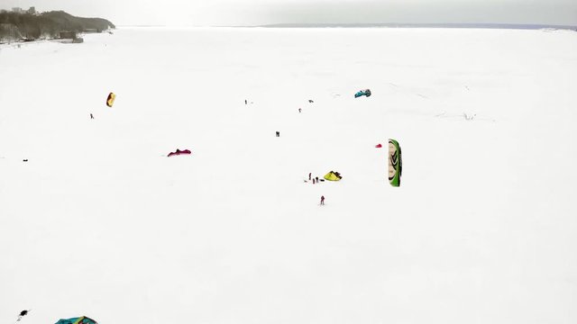 CHEBOKSARY, RUSSIA - DECEMBER 31, 2018: Athletes involved in snowkiting, in the winter ride on the river in the costumes of Santa Claus, aerial photography from a quadrocopter