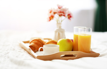 breakfast in bed of coffee, croissants, orange juice and fruit on tray - obrazy, fototapety, plakaty