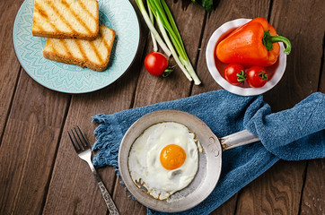 Vegetarian breakfast of fresh vegetables and avocado on a wooden table.