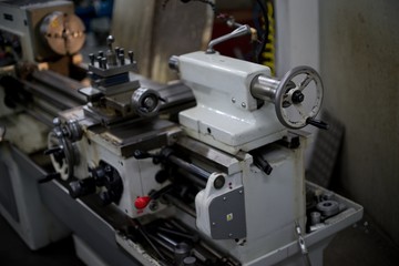Lathe machine for metal cutting, machinery center background.