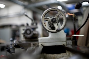 Lathe machine for metal cutting, machinery center background.