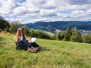 Woman artist working en plein air in mountains.