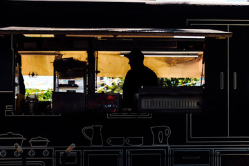 Silhouette of a seller inside a food truck