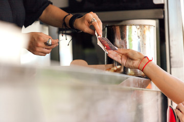 Close-up of woman's hand paying on a food truck