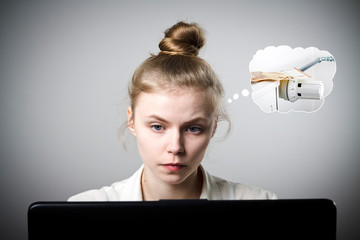 Young slim woman with laptop. Heating season, taxes and saving concept. Radiator.