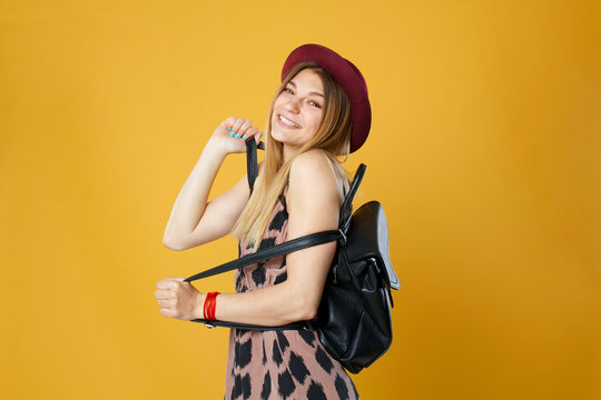 Happy tourist woman holding travel yellow case and credit card. Studio portrait. Vacation concept.