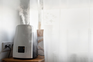 Stylish air humidifier near the window in the children's room. Humidification and purification of air in the square.