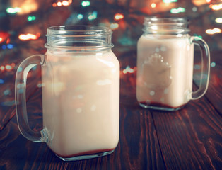 Two glass cups  of hot cocoa with milk and sugar, on wooden table