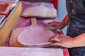 Making a traditional homemade pizza. Close up picture shot outside on a sunny day in a french farmer's market of Quebec, Canada.