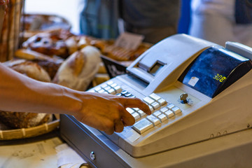 Operating an old school cashier. Close up picture shot outside on a sunny day in a french farmer's...