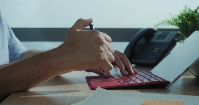 Sad businessman working with laptop computer in office. Anxious business man under stress at work with pc. Young white manager worried for technology problem and clicking on pen for time pressure