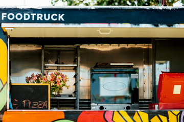 Window of a food truck with signs of pizza and food truck