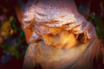 Beautiful sad angel. Vintage styled image of antique statue. Fragment of sculpture. Religion, faith, death, eternity concept.