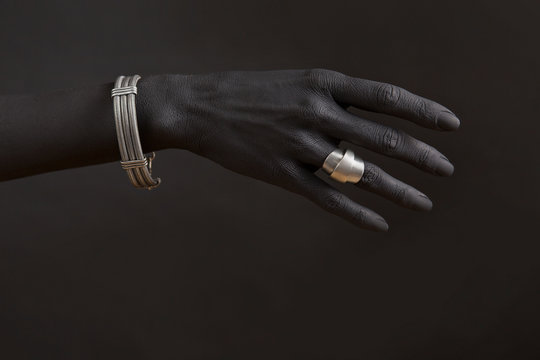 Black woman's hand with Silver jewelry.