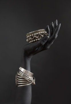 Black Woman's Hand With Silver Jewelry. Oriental Bracelets On A Black Painted Hand. Silver Jewelry