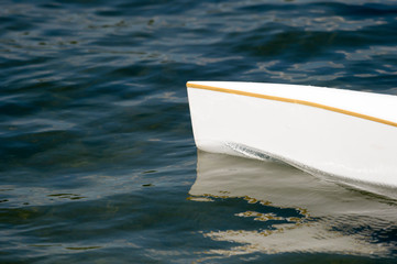 White canoe, kajak and rowing on lake water.
