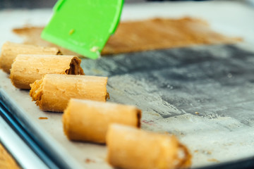 Close-up macro of spatula making caramel ice cream roll