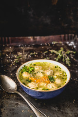 fresh meatball soup in bowl on dark background