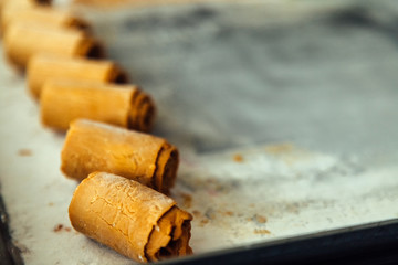 Close-up macro of caramel ice cream rolls on steel plate
