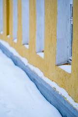 Facade of a winter house with yellow wall