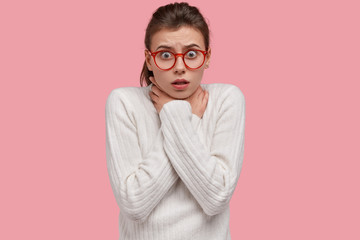 Scared Caucasian woman holds hands on neck while chocks from fright, commits suicide, wears white...