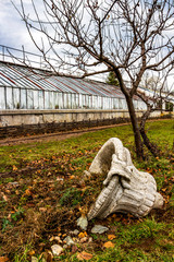 Fallen decorative vase and the neglected building of the orangery of Vrana Palace in Sofia, Bulgaria, a former royal palace, left to decay
