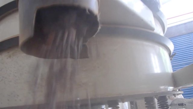 Clean Cacao Beans Falling Out From a Machine in a Warehouse 