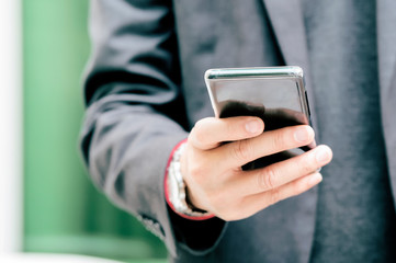 Close up of a business man using mobile smart phone