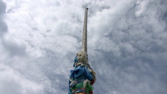 Shaman obo sacrifices on stones on background of clouds in Mongolia.