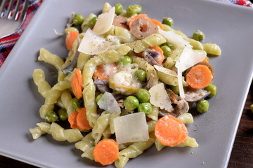 Spinach pasta with spinach and gorgonzola dressing with peas and carrots  