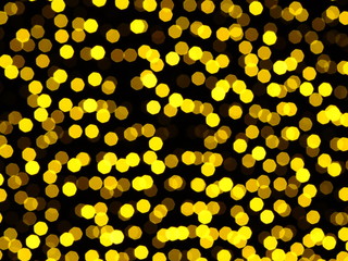 Gold christmas lights in night. Sparkling festive background of golden Christmas lights ob black background