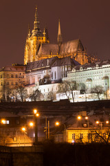 Night snowy Christmas Prague Lesser Town with gothic Castle above River Vltava, Czech republic