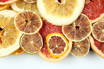 Dried slices of various citrus fruits closeup on white background