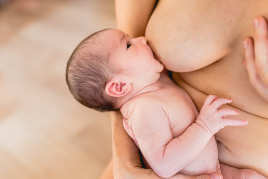 Young woman breastfeeding a baby newborn.