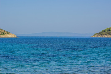 Fototapeta premium picturesque symmetry tropic scenic landscape with islands coast on both sides of photography and vivid blue water surface of sea bay on foreground, summer vacation and tourist agency concept