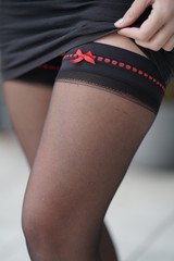 Stockings with red ribbon on woman legs