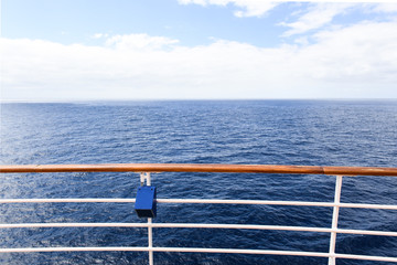 Steel and metal railing of a cruise ship with he ocean in the background