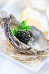 Fresh oysters with black caviar. Opened oysters with black sturgeon caviar. Gourmet food. Delicatessen. Vertical image