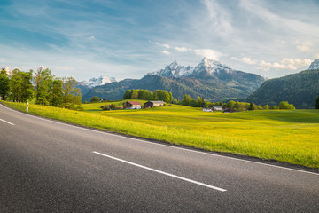 Empty asphalt country road with alpine mountain scenery in summer
