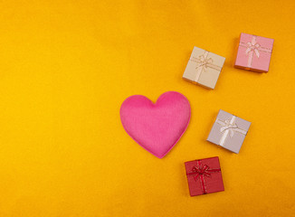 Valentines day background with red heart and gift box on glitter lights gold background.