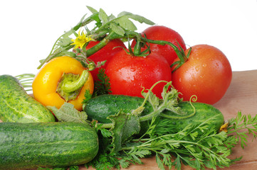 Tomatoes and cucumbers on the kitchen board. Close-up