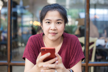 Women using smartphone sitting in modern coffee shop